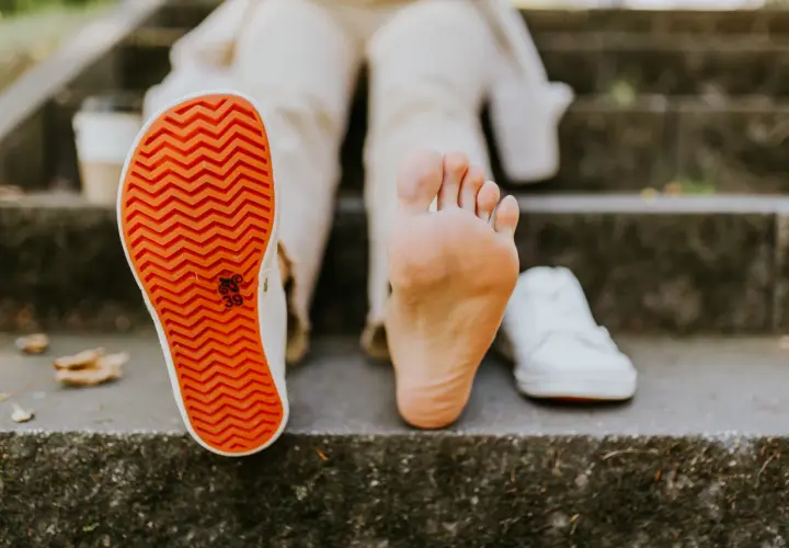 Naga stopa obok buta. **Barefoot co to znaczy**? To wolność i kontakt z podłożem, jak na schodach.