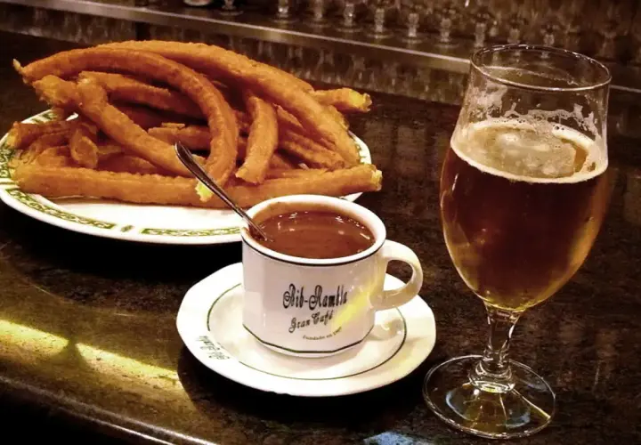 Churros con chocolate y una cerveza, cosas típicas de España.
