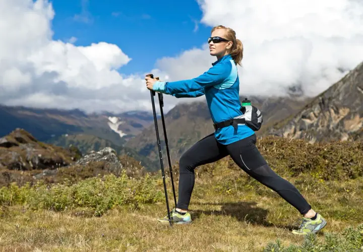 Kobieta ćwiczy nordic walking w górach. Po miesiącu regularnych treningów widać pierwsze efekty: lepszą kondycję i smuklejszą sylwetkę.