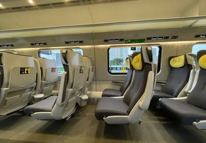 Komfortowe fotele w nowoczesnym pendolino wnetrze. Jasne wnętrze pociągu z wygodnymi siedzeniami i żółtymi zagłówkami.