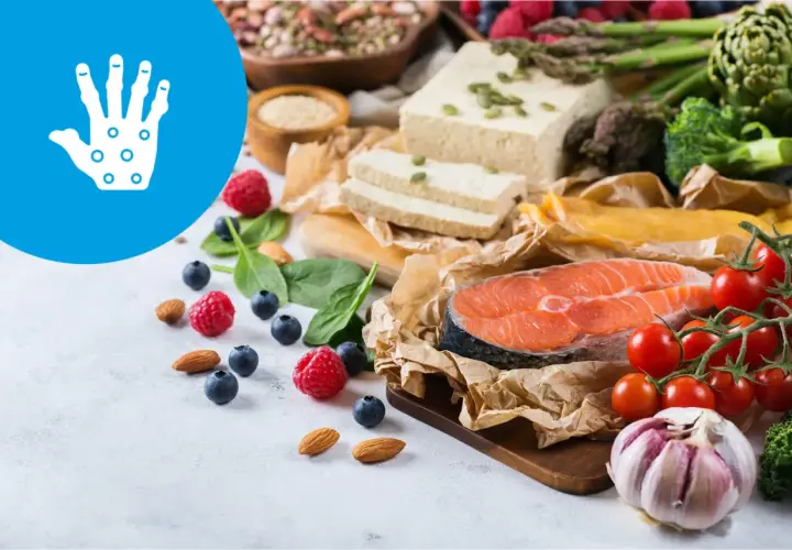 Zdrowa dieta przy łuszczycy: łosoś, warzywa, owoce, orzechy i tofu. Ikona dłoni symbolizuje problemy skórne.