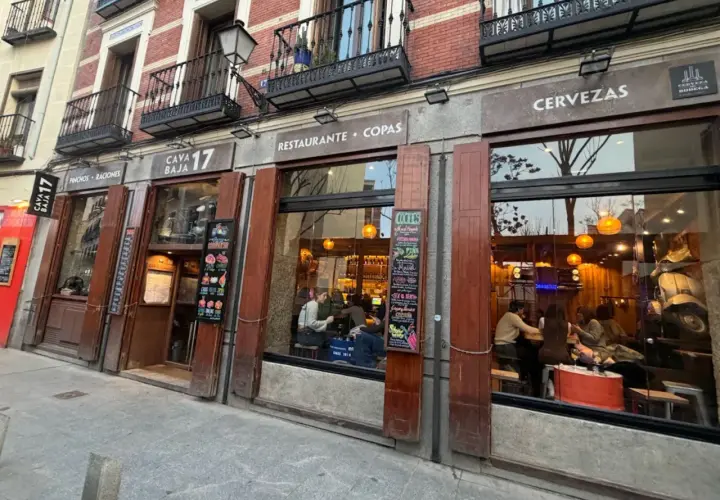 Fachada del restaurante Cava Baja 17, con gente dentro disfrutando de tapas y copas.