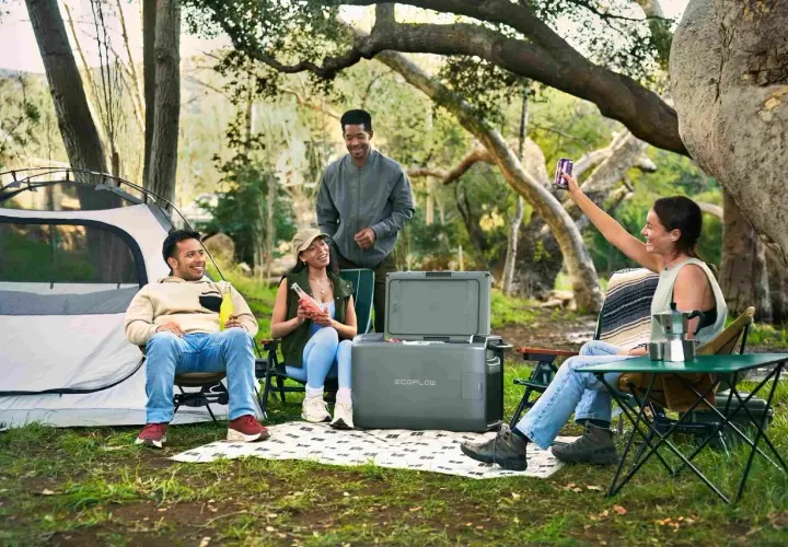 Amis profitant d'un camping chez l'habitant en France, avec tente, glacière et boissons.