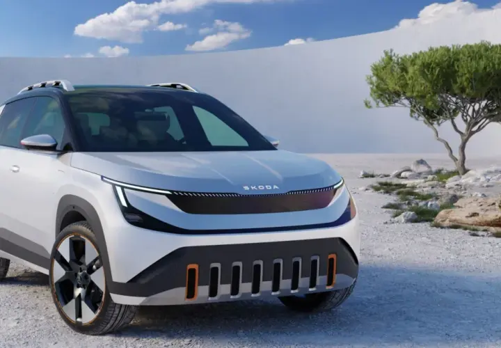 Biały Skoda Enyaq z czarnym dachem i relingami stoi na kamienistym pustkowiu.