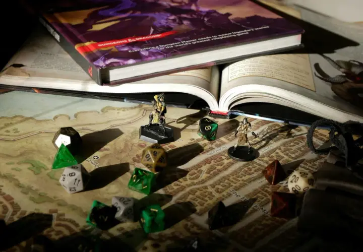 Księga Dungeons & Dragons, kostki do gry i figurki na mapie. Przygotowania do sesji dnd.