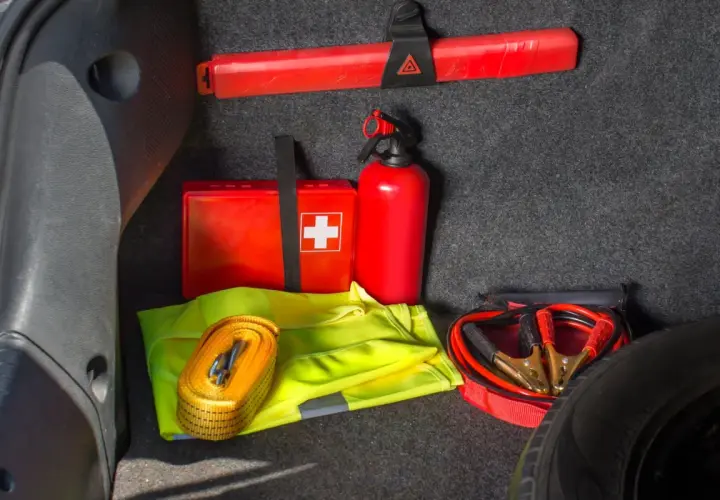 Czy apteczka jest obowiązkowa w samochodzie? W bagażniku widać apteczkę, gaśnicę, trójkąt, kamizelkę odblaskową i kable rozruchowe.