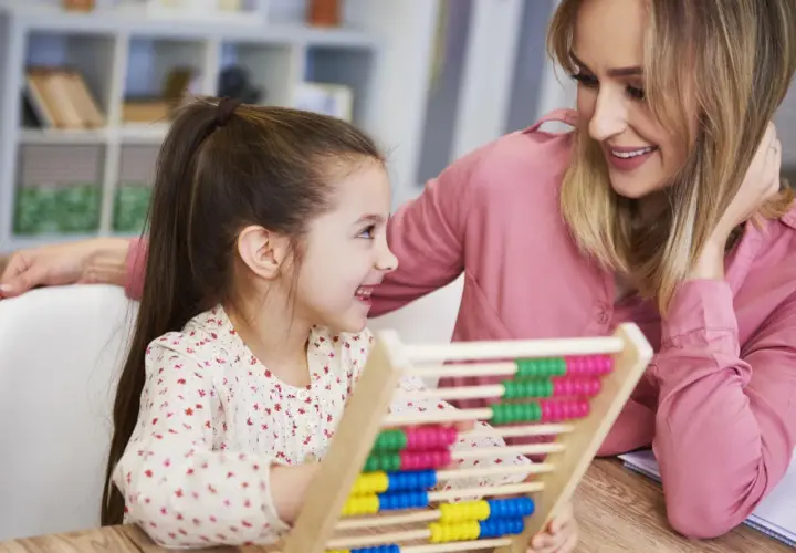 Mutter und Kind üben mit einem Abakus. Ein fröhlicher Moment vor der Einschulung, der den ersten Mathe-Test spielerisch vorbereitet.