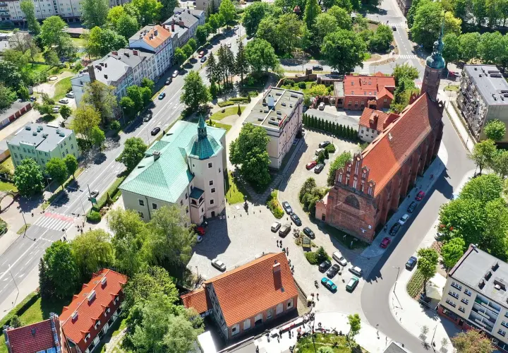 Słupsk atrakcje: widok z lotu ptaka na zamek Książąt Pomorskich z zielonym dachem i gotycki kościół.