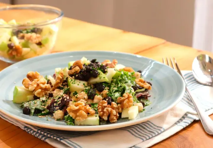 Deliciosa ensalada de manzana con nueces, pasas y semillas. Un plato fresco y nutritivo.