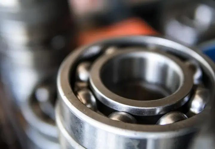 Zbliżenie na metalowe łożysko kulkowe z widocznymi kulkami.