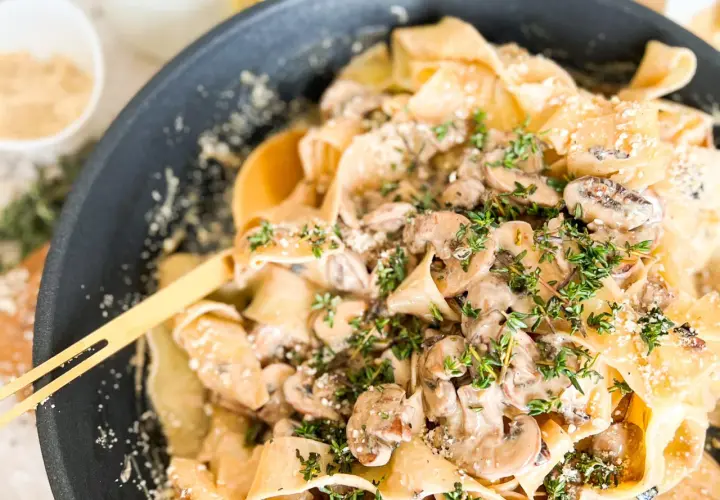 Cremige Pasta mit Pilzen und frischem Thymian, garniert mit Parmesan. Ein köstliches Gericht, das Lust auf mehr macht.