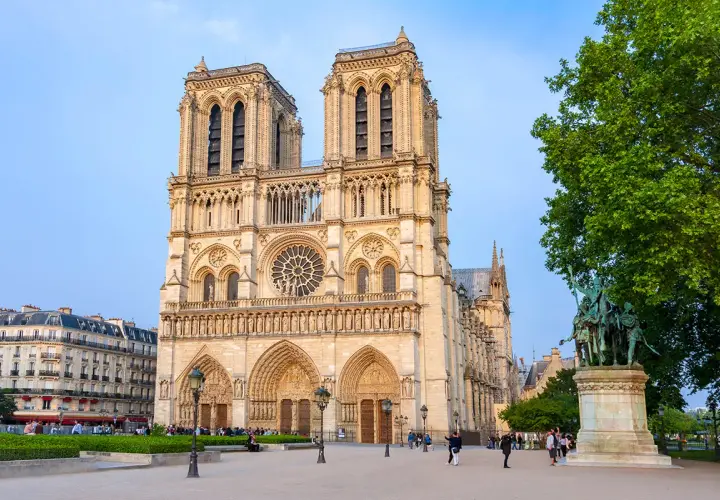 Katedra Notre Dame w Paryżu z placem i pomnikiem w słoneczny dzień.