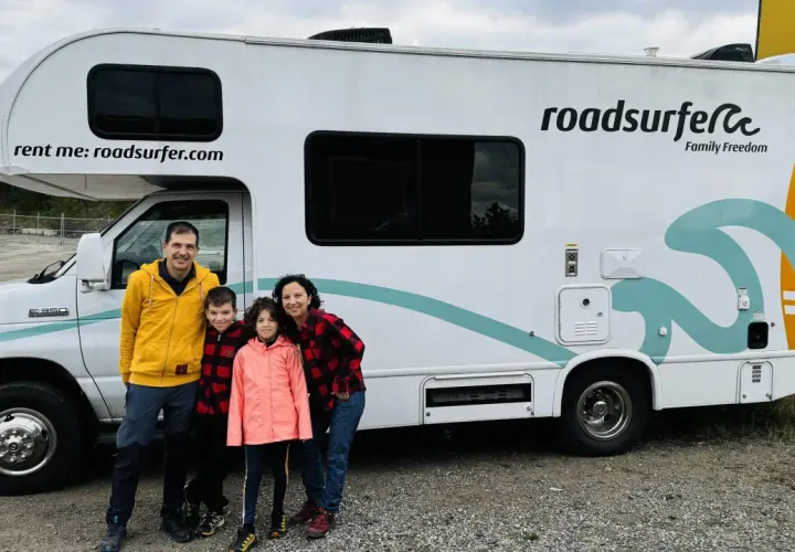 Famille souriante devant un camping-car Roadsurfer prêt pour un road trip Canada. L'aventure commence !