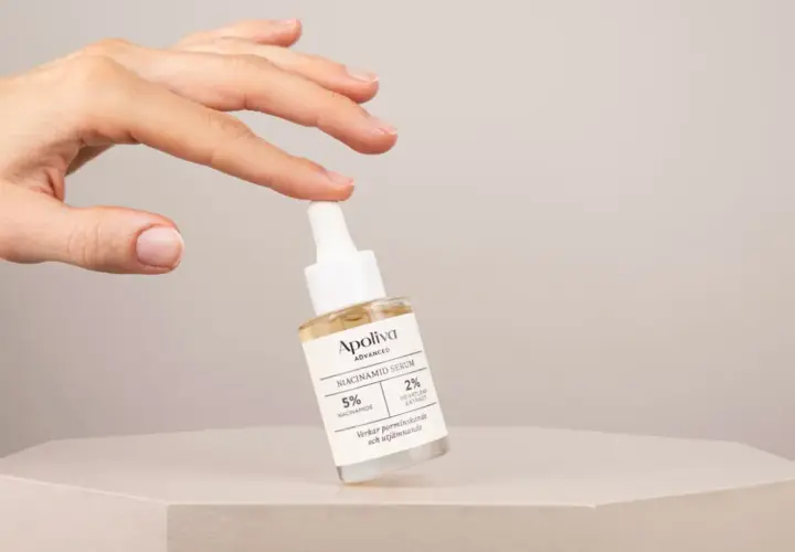 En hand håller en flaska Apoliva Niacinamid Serum, en viktig del av din niacinamide hudvård för en jämnare hy.