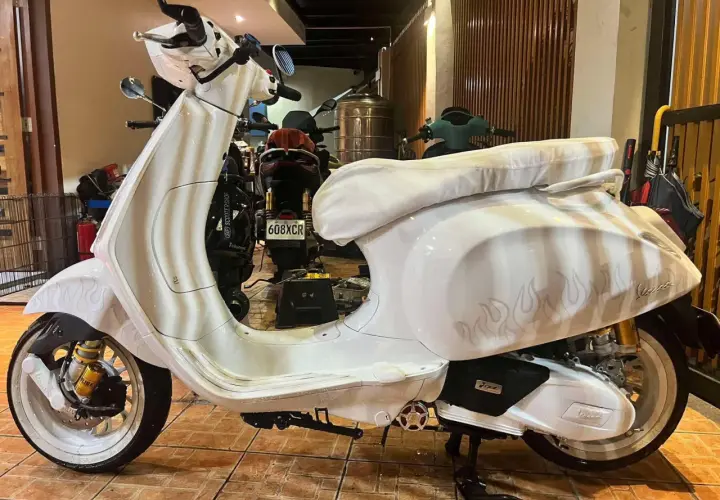 Vespa bianca personalizzata con fiamme, un vero gioiello a 2 tempi pronto a sfrecciare.