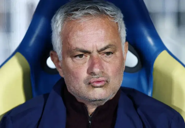 Jose Mourinho, były trener Realu Madryt, siedzi na ławce rezerwowych, zamyślony.