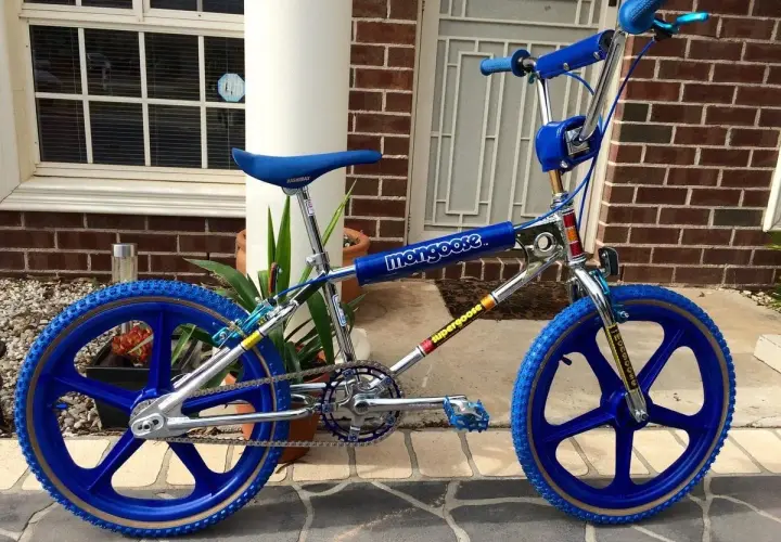 A blue Mongoose Supergoose BMX bike, a classic from the 1980s bicycle brands, with chrome accents and blue mag wheels.