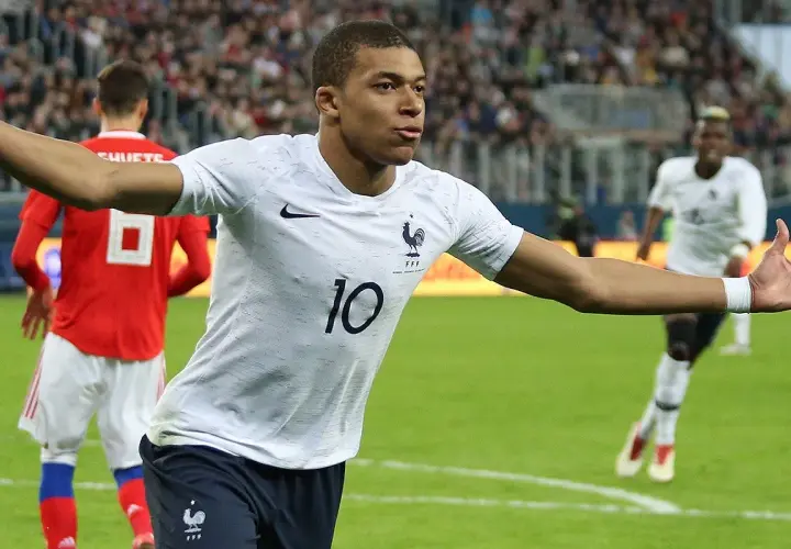 Kylian Mbappé w białej koszulce z numerem 10, świętuje bramkę. Jego waga jest idealna do szybkich sprintów.