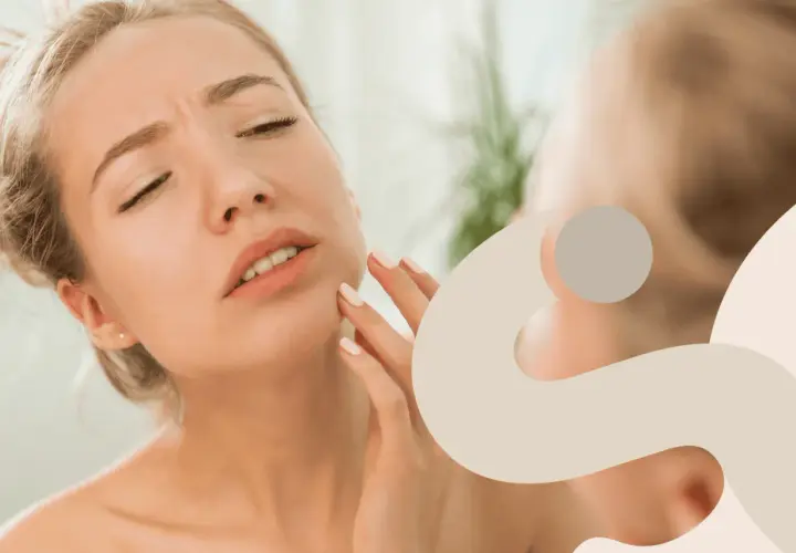 Donna con viso irritato che si tocca la guancia, preoccupata per la sua pelle.