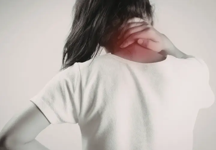 Dolor en el trapecio musculo. Una persona se sujeta el cuello, con una zona enrojecida indicando molestia.