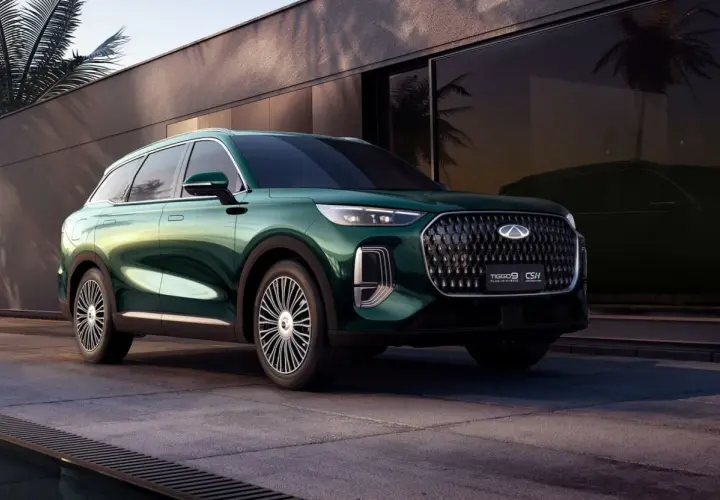 Elegancki, zielony Tiggo 9 Plug-in Hybrid prezentuje się stylowo na tle nowoczesnej architektury z palmami.