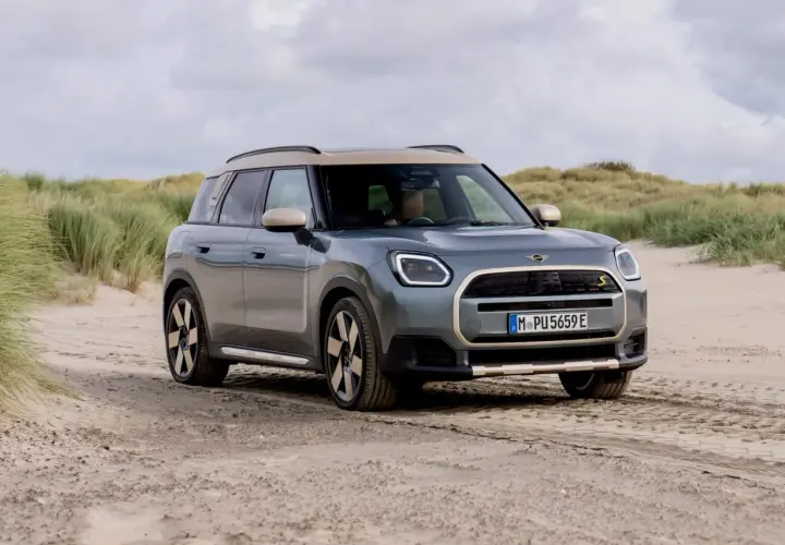 Grå Mini Countryman på sandig väg vid en strand. En spännande mini countryman test i en unik miljö.
