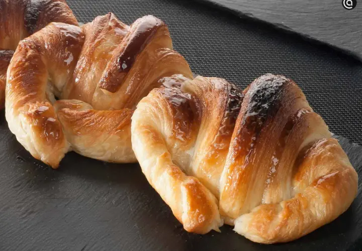 Deliciosos croissants dorados y brillantes, perfectos para aprender como hacer croissant casero.