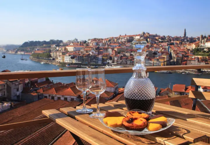 Un bicchiere di **douro vino** e dolci su un tavolo con vista su Porto.