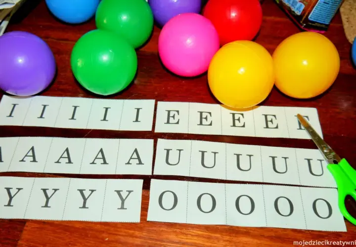 Kolorowe piłeczki i paski z literami: I, E, A, U, Y, O. Czy to nauka, ile jest samogłosek w języku polskim?