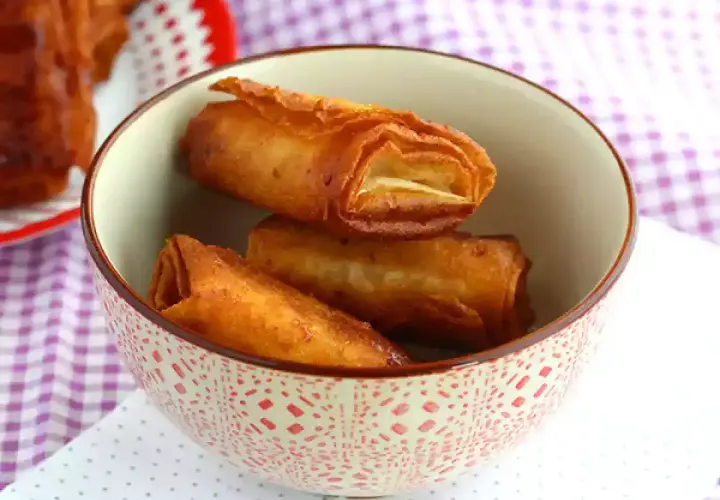 Krispiga, gyllene rullar med friterad banan panko i en mönstrad skål.