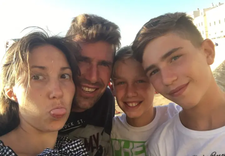 Famiglia in vacanza con ragazzi di 15 anni, sorrisi e sole.