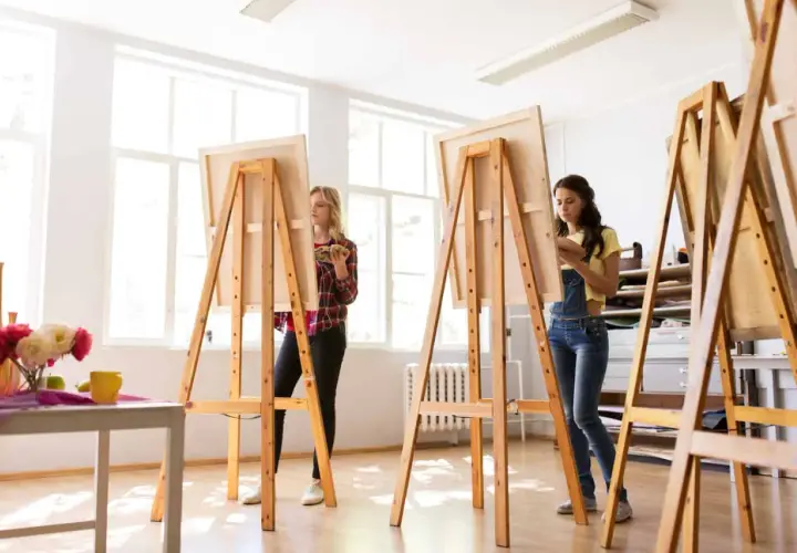 Zwei Frauen malen in einem hellen Atelier. Sie stehen vor Staffeleien, die aussehen, als ob sie jemand selber bauen könnte.