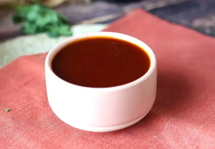Un bol de sauce barbecue maison, parfaite pour accompagner vos grillades. Une recette simple pour un goût authentique.