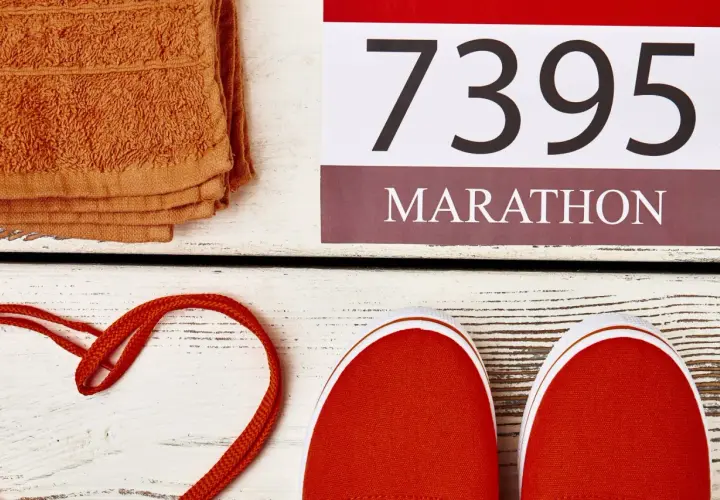 Pomarańczowy ręcznik, czerwone buty i numer startowy 7395 z napisem MARATON. Czas na maraton!