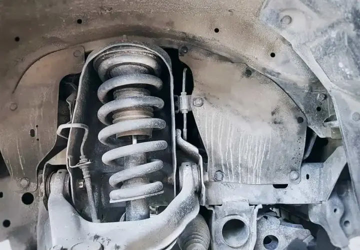 Primer plano de un amortiguador de coche, parte esencial para el confort y la seguridad.