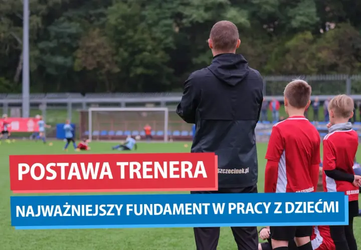 Trener piłki nożnej obserwuje młodych zawodników na boisku. Jego postawa to fundament pracy z dziećmi.
