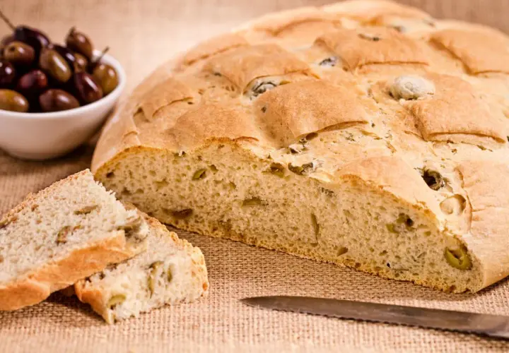 Un delicioso pan italiano con aceitunas, recién horneado y listo para disfrutar.