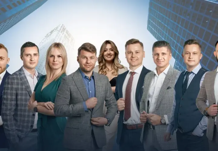Grupa profesjonalistów w garniturach na tle nowoczesnych budynków.
