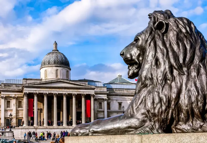 Lew przed monumentalnym budynkiem Muzeum Narodowego w Londynie.