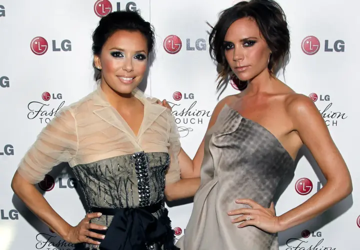 Eva Longoria i Victoria Beckham pozują do zdjęć, obie w eleganckich kreacjach. Ich uśmiechy i gesty sugerują radosne wags.