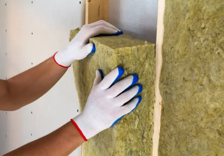 Mani guantate posizionano un pannello isolante per creare un solaio termico efficiente.