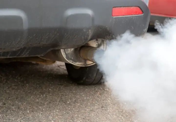 Fumo bianco dalla marmitta diesel di un'auto, che si disperde nell'aria.