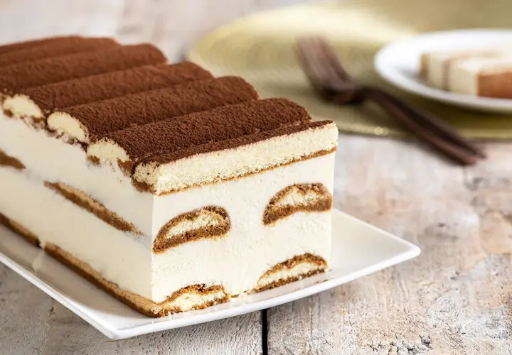 Tiramisù cremoso, uno dei dolci senza glutine perfetti per ogni occasione. Strati di savoiardi e crema, spolverati di cacao.