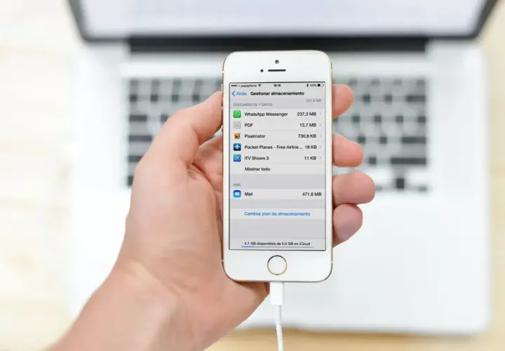Mano sujetando un iPhone mostrando la gestión de almacenamiento, útil para la copia de seguridad iPhone.