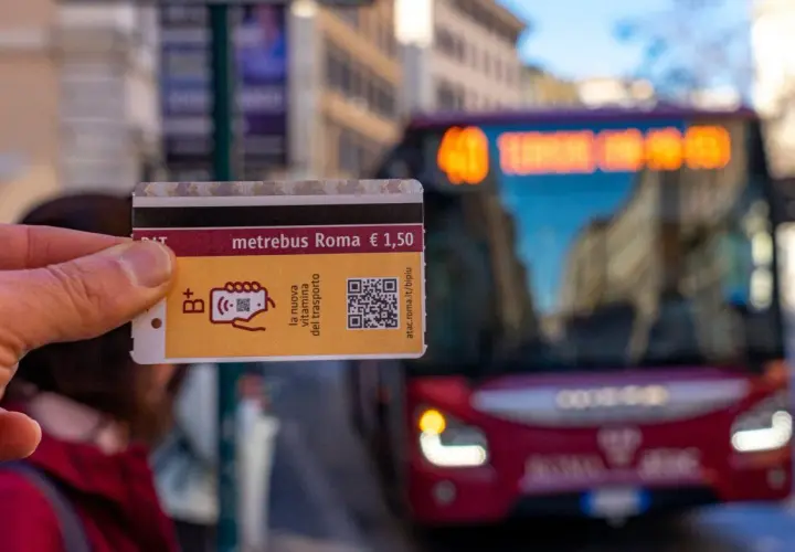 Un biglietto Metrebus Roma da 1,50€, la nuova vitamina del trasporto, pronto per essere usato su un bus rosso in città.