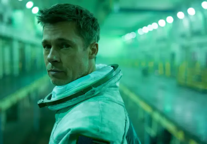 Brad Pitt w skafandrze kosmicznym w filmie Ad Astra, w zielonej poświacie tunelu.