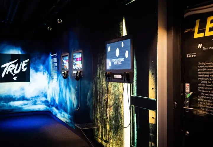 Utställning på Avicii museum med skärmar och hörlurar. En skärm visar texten "IF THOSE LISTENERS WERE EGGS".