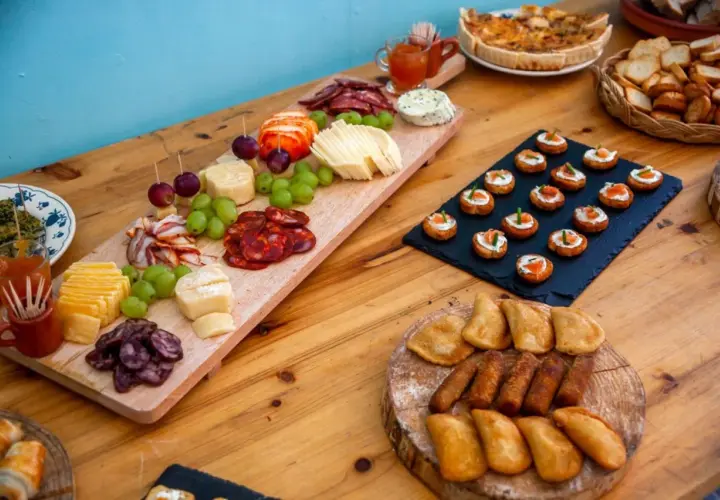Un buffet champêtre gourmand : planches de charcuterie, fromages, raisins, mini-quiches et toasts saumon.