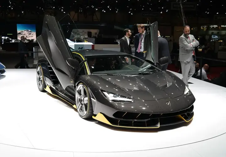 Ciemnoszary Lamborghini z otwartymi drzwiami, żółtymi akcentami. Zastanawiasz się, ile kosztuje Lamborghini? Ten model robi wrażenie!