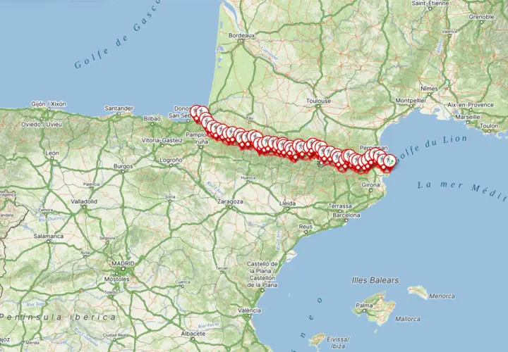 Mapa de la ruta transpirenaica con marcadores de senderismo desde el Atlántico hasta el Mediterráneo, pasando por ciudades como San Sebastián, Pamplona y Girona.